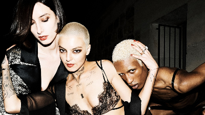 Three people posing together with a dark background